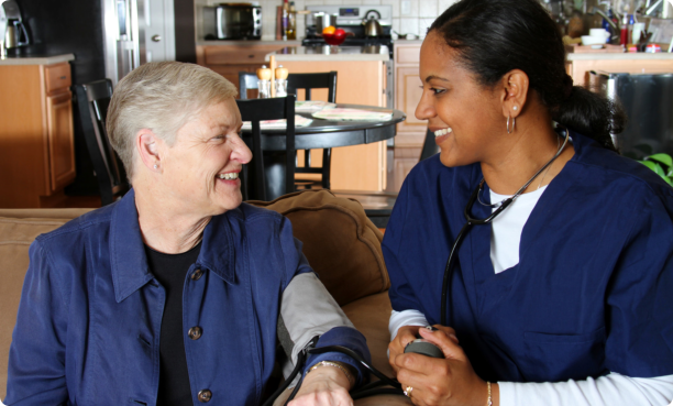 Nurse checking blood pressure of old lady